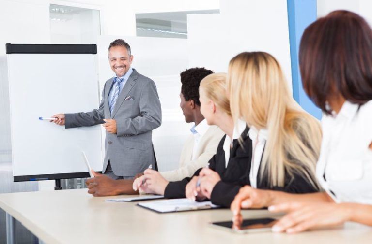 21328368 - businesspeople looking at businessman explaining in presentation
